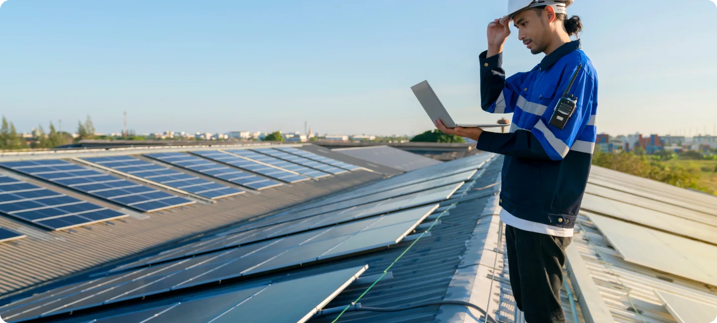 Technician inspecting roof with solar panels